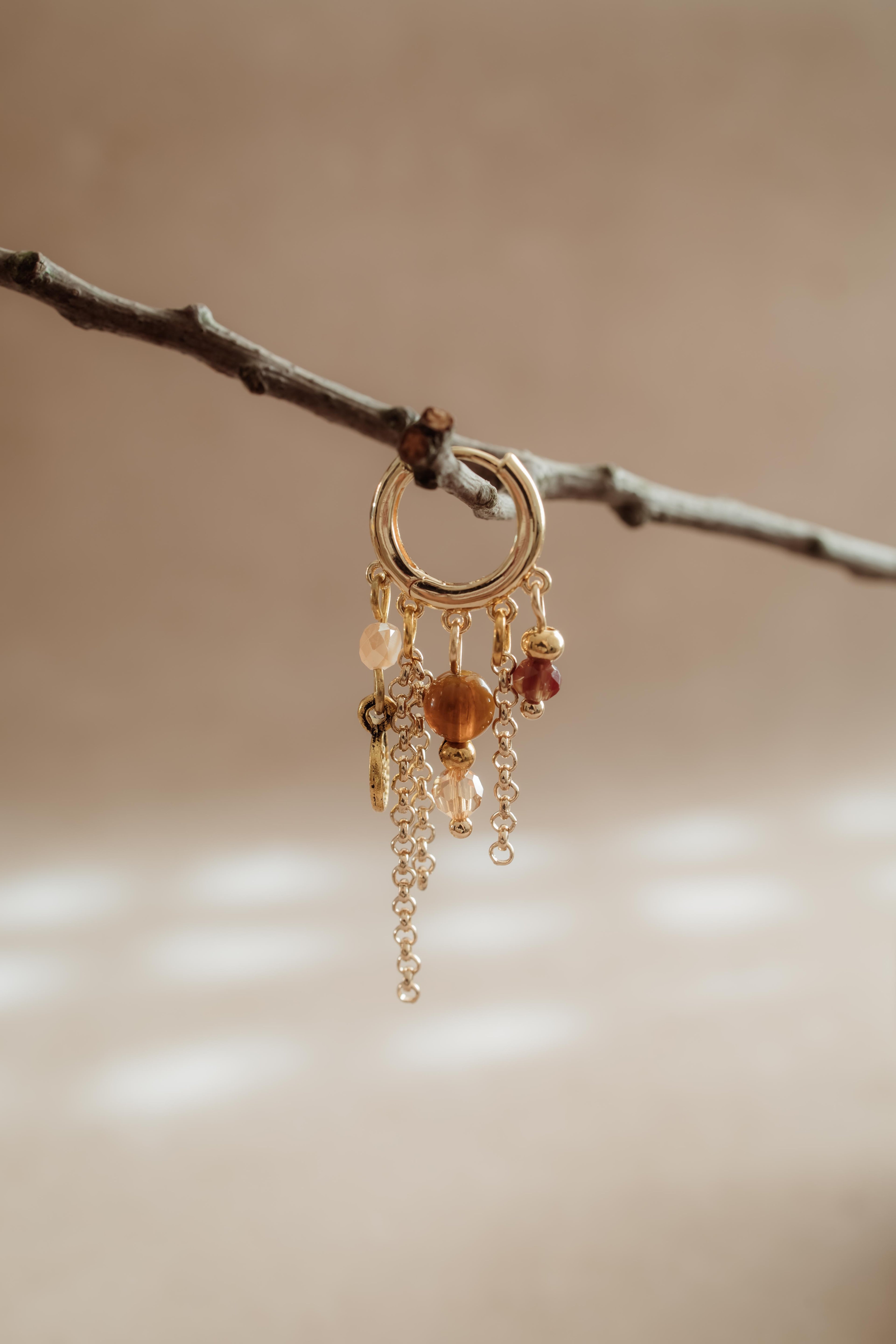 Stainless steel oorring in goud met verschillende bedeltjes uit de PURE // ONE collectie van Pure Black Styling