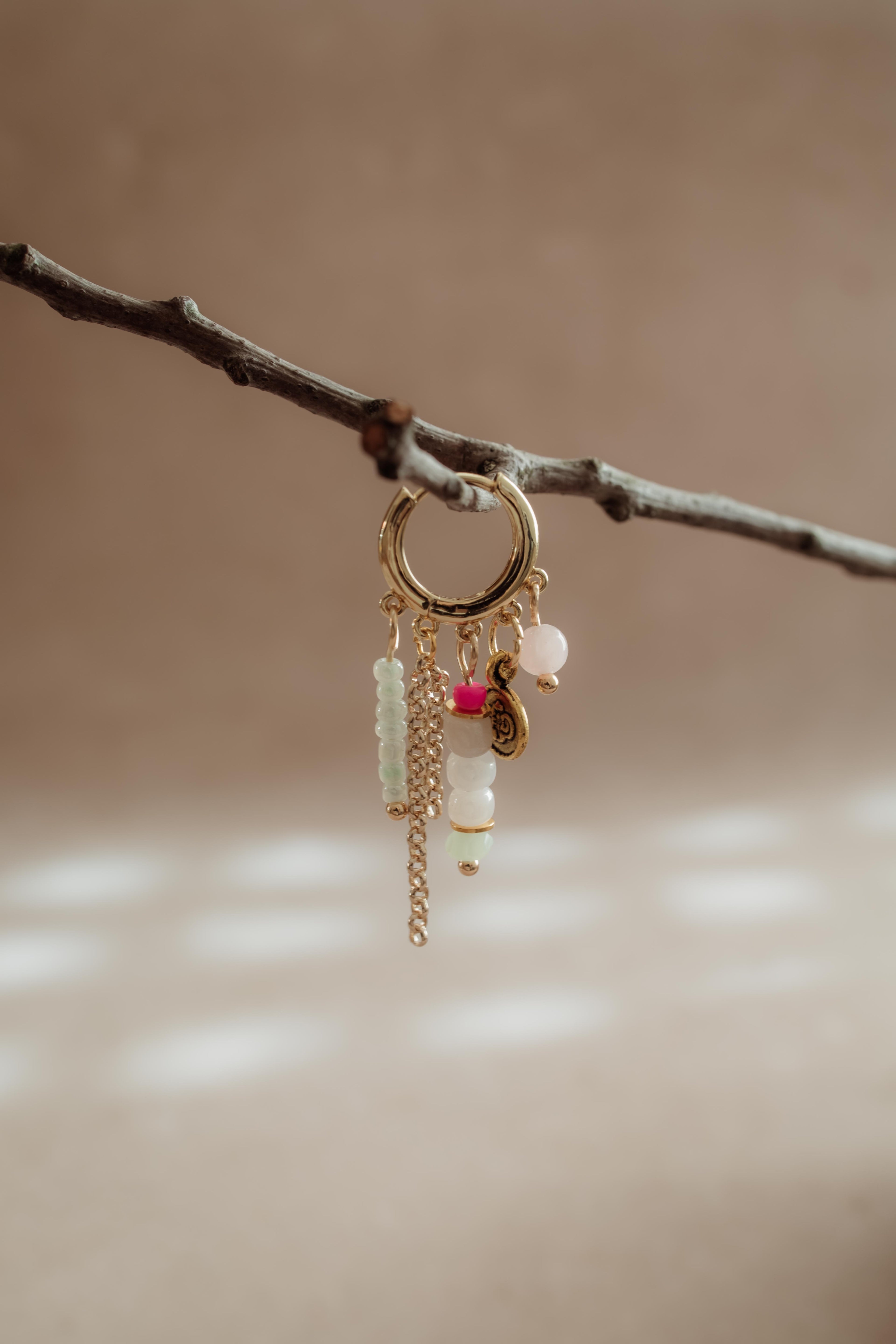 Stainless steel oorring in goud met verschillende bedeltjes uit de PURE // ONE collectie van Pure Black Styling