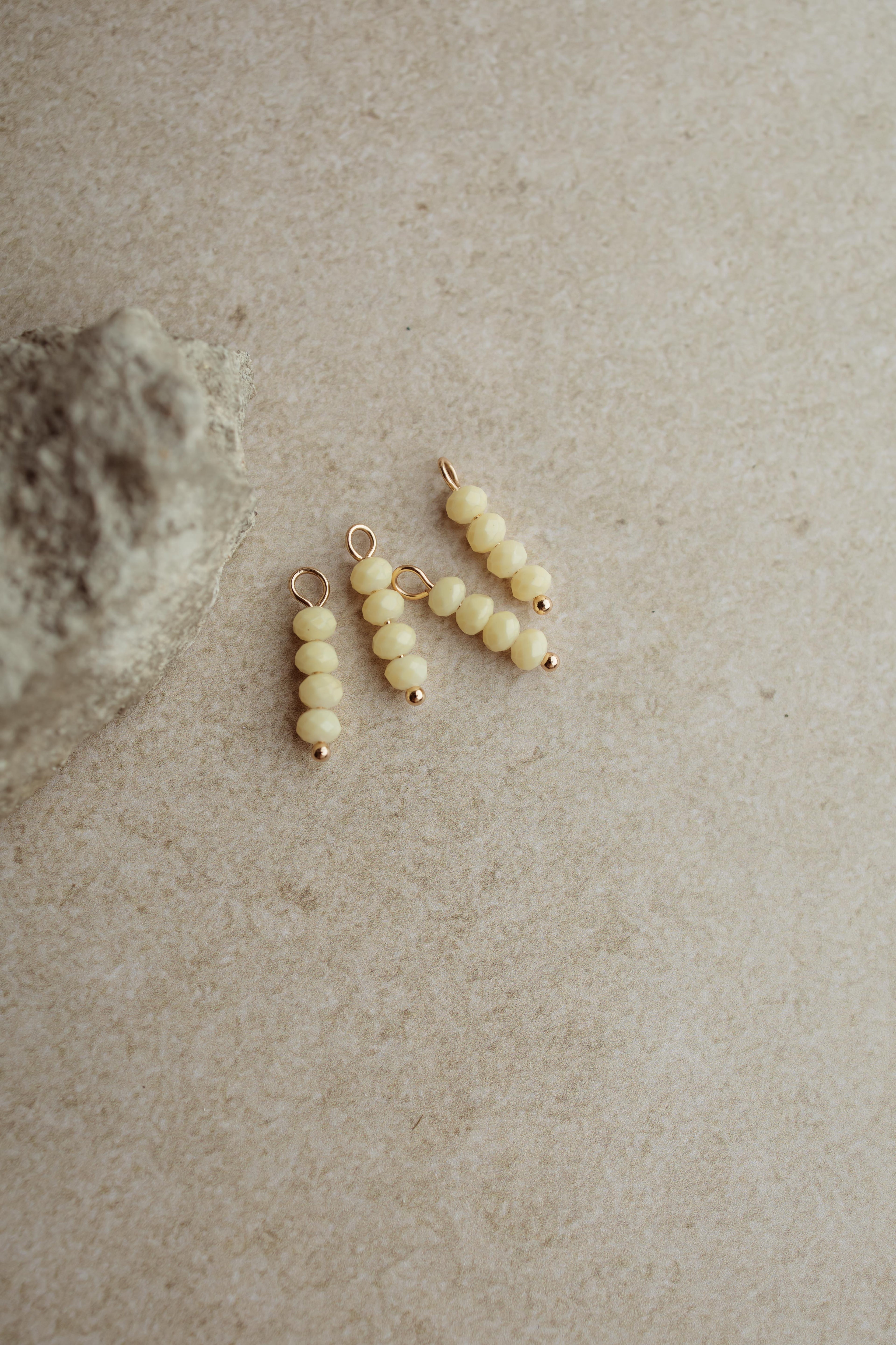 Botergeel ofwel de butteryellow trend is ook verkrijgbaar bij Pure Black Styling! Shop dit gouden bedeltje met kraaltjes nu!