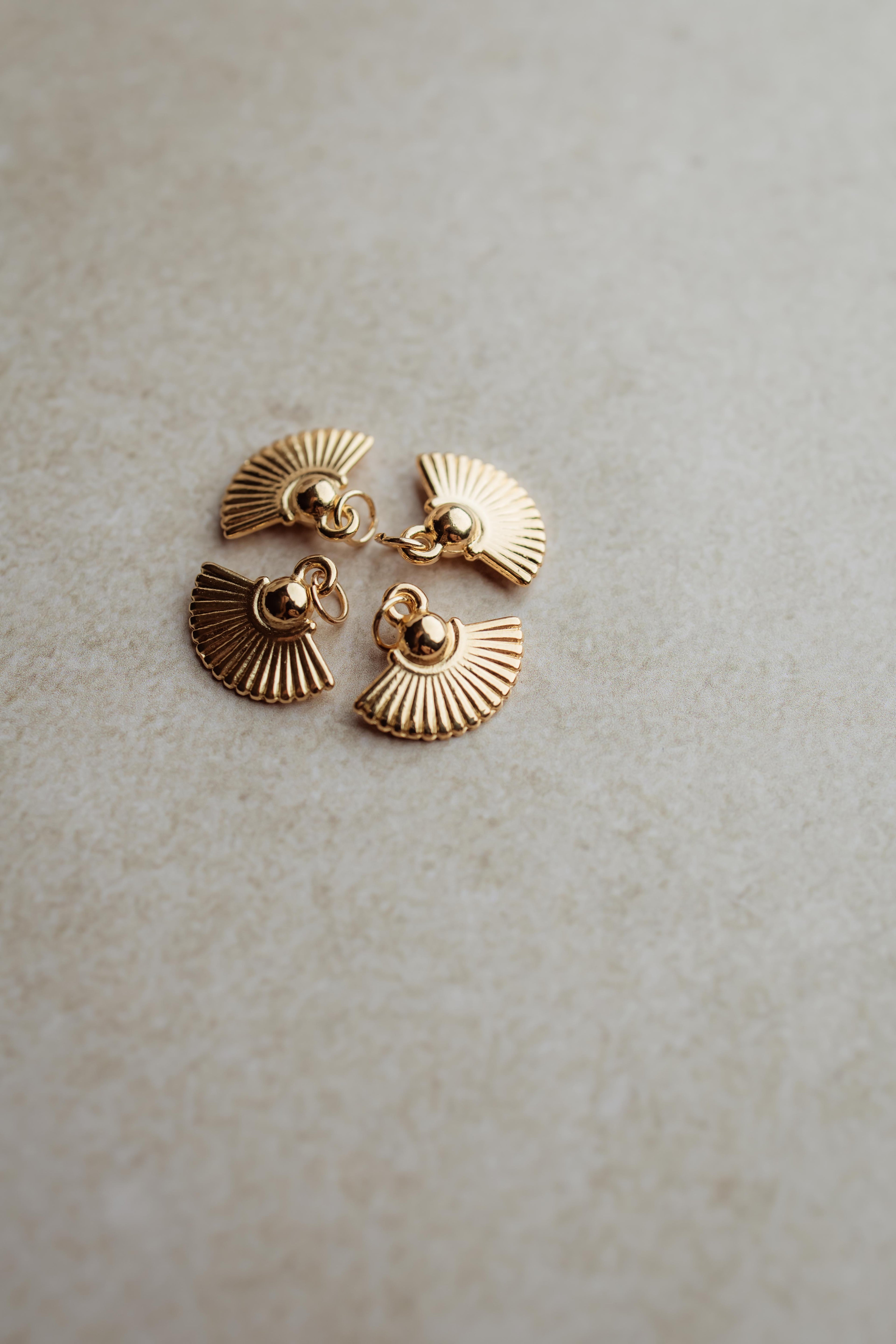 Gouden bedeltje voor aan oorringen of oorbellen.